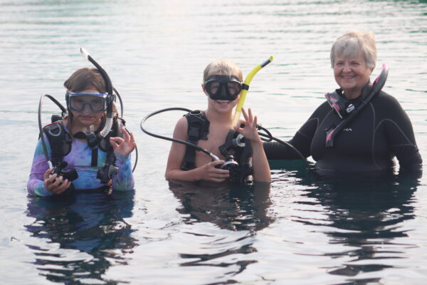 Image of two campers scuba diving with an instructor.