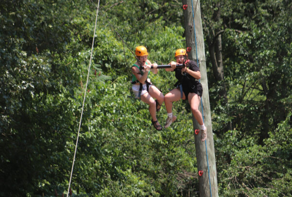 Image of two girls zip lining.