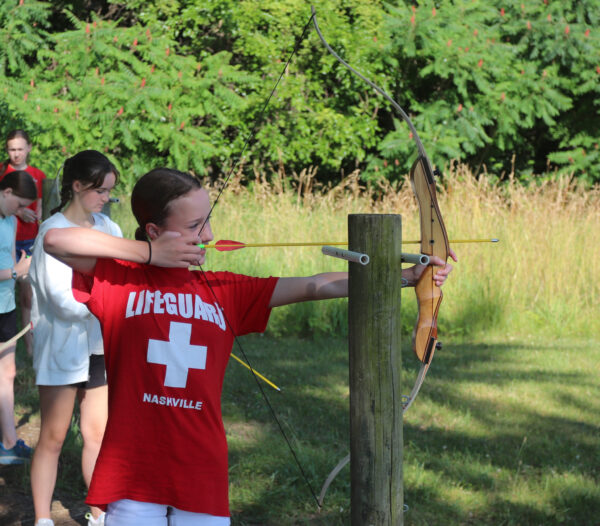 image of a female camper practicing archery.