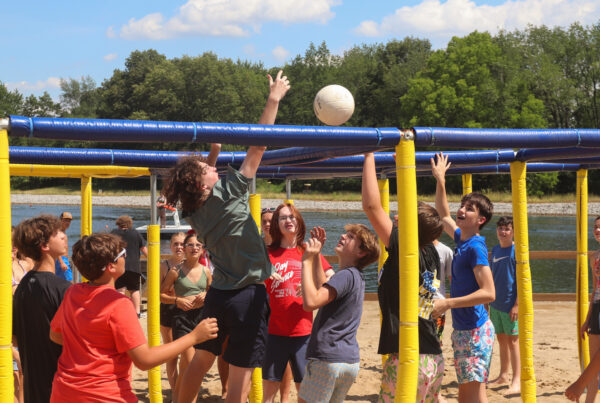 image of several children playing nine square on the beach.