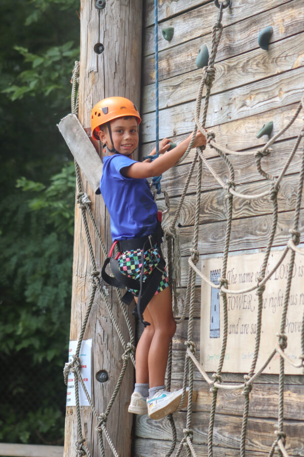 Image of a young boy climbing the rock tower.