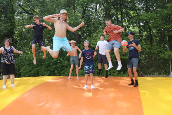 image of several boys jumping on the jumping pillow.