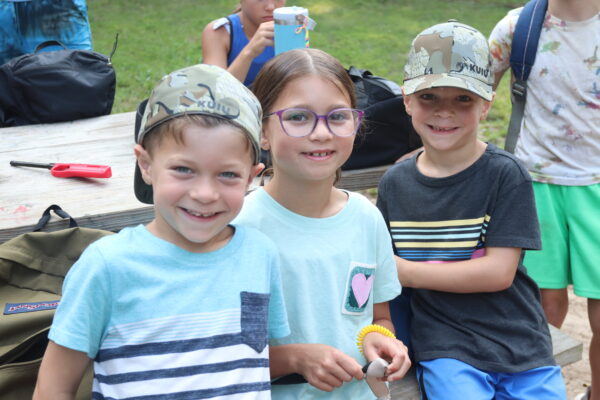 Image of three young campers smiling for the camera