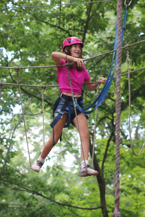 image of a camper taking on the high ropes course.
