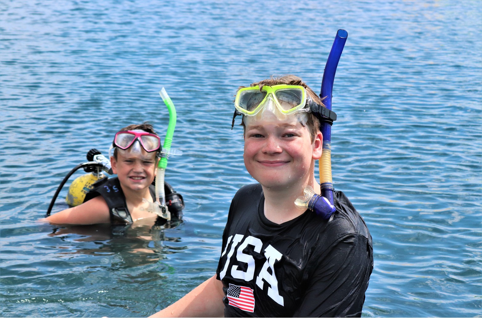 image of two boys scuba diving in the lake.