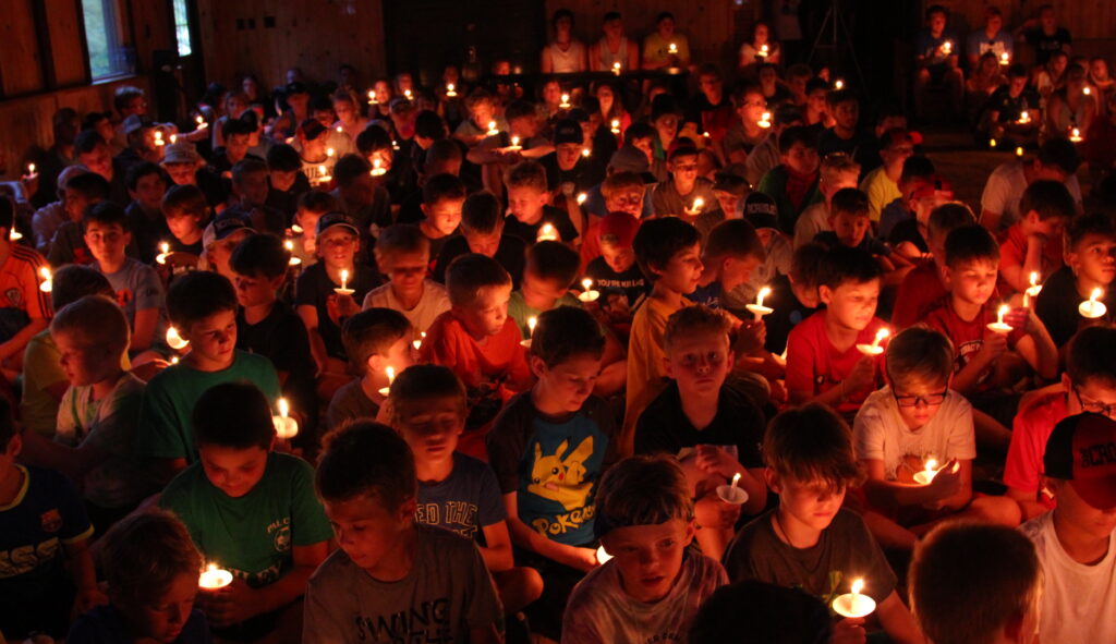 Group of campers holding candles at the Camp Crosley closing ceremony.