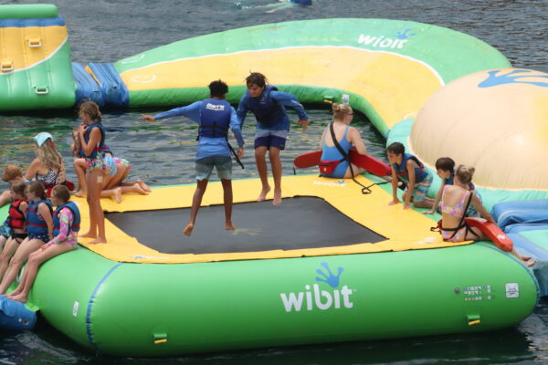 A group of children wearing life jackets playing in the H2O Woah Zone.