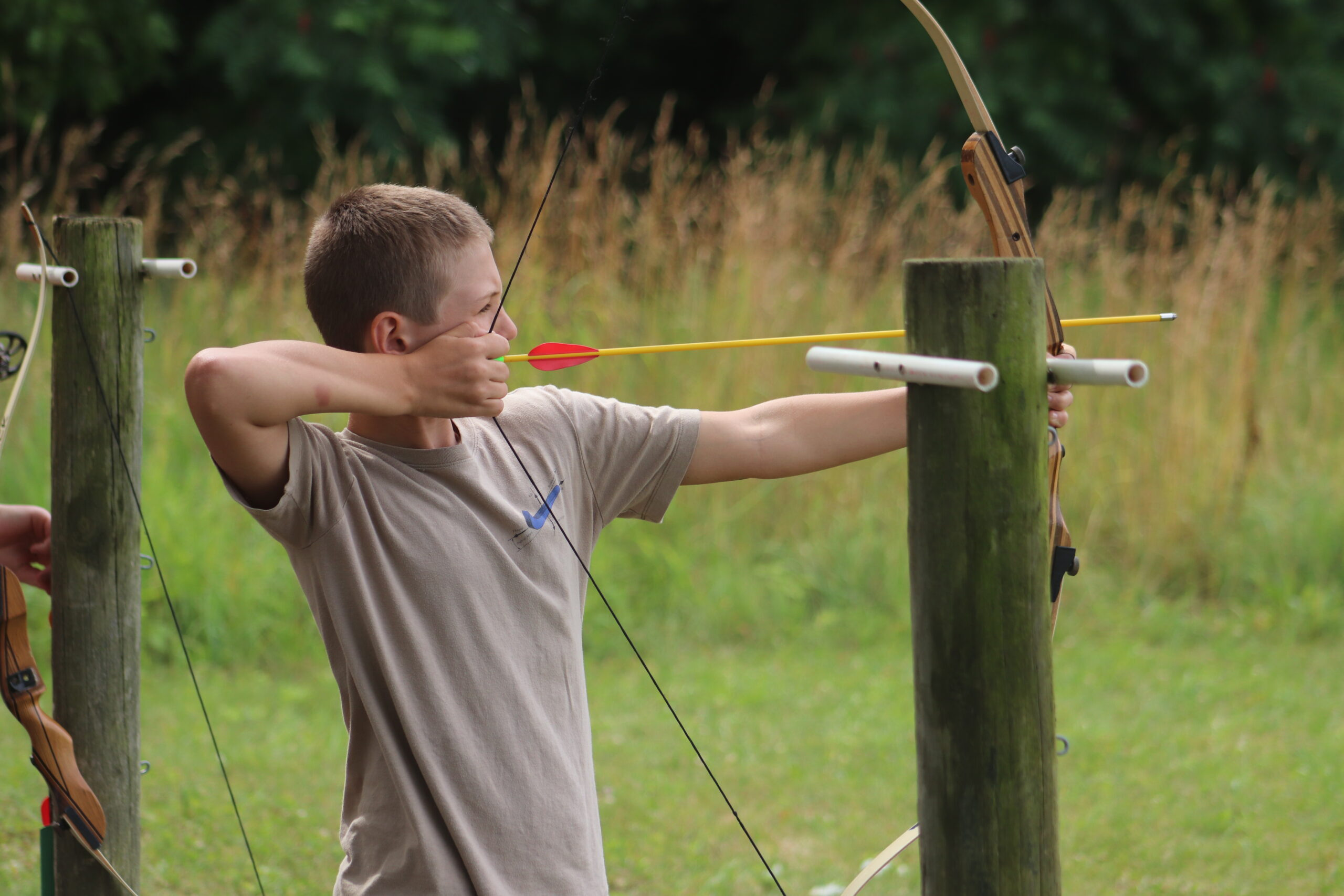 a boy practicing archery outdoors.